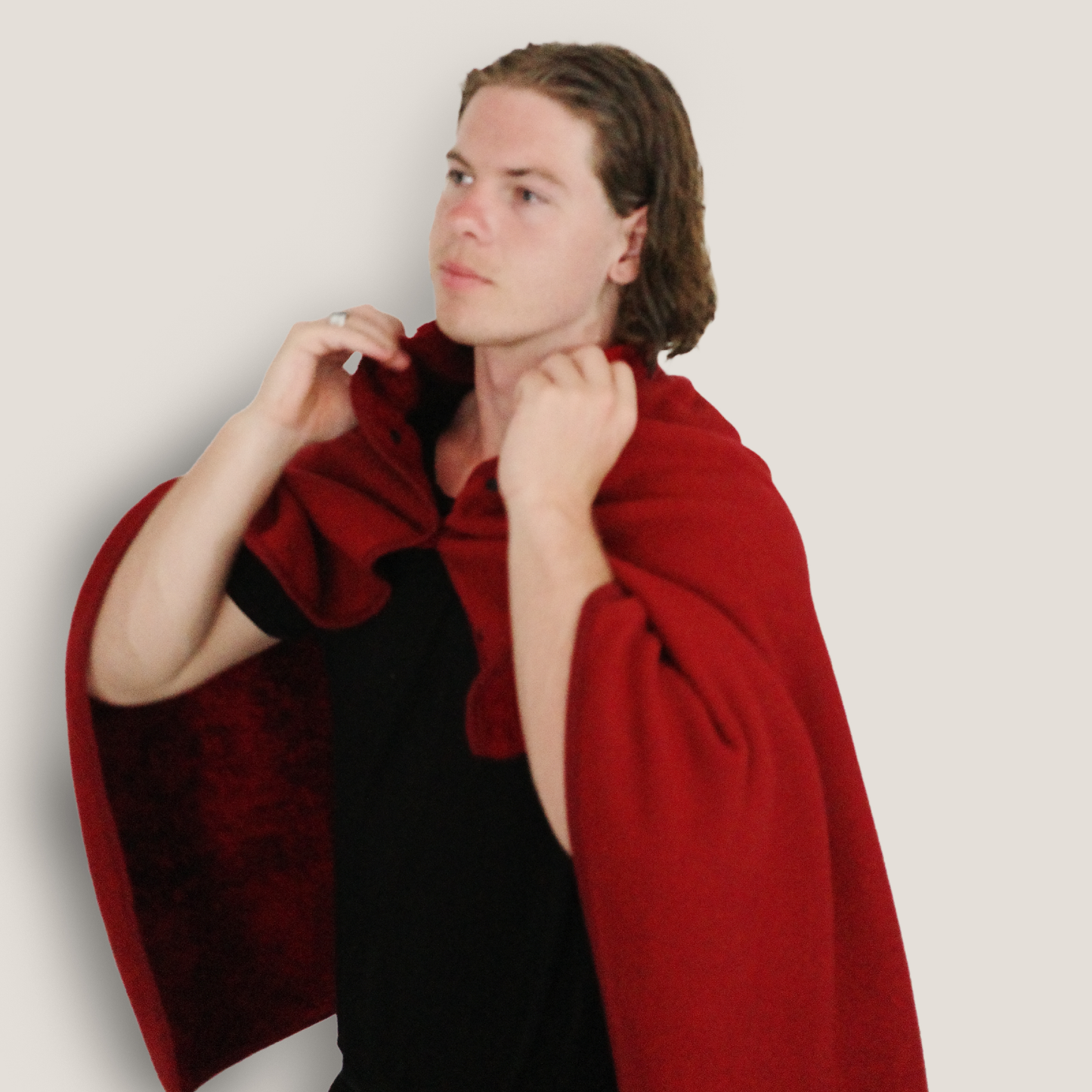 Man wearing a deep red wearable blanket cape, showcasing its warmth, comfort, and versatile style for indoor and outdoor coziness.