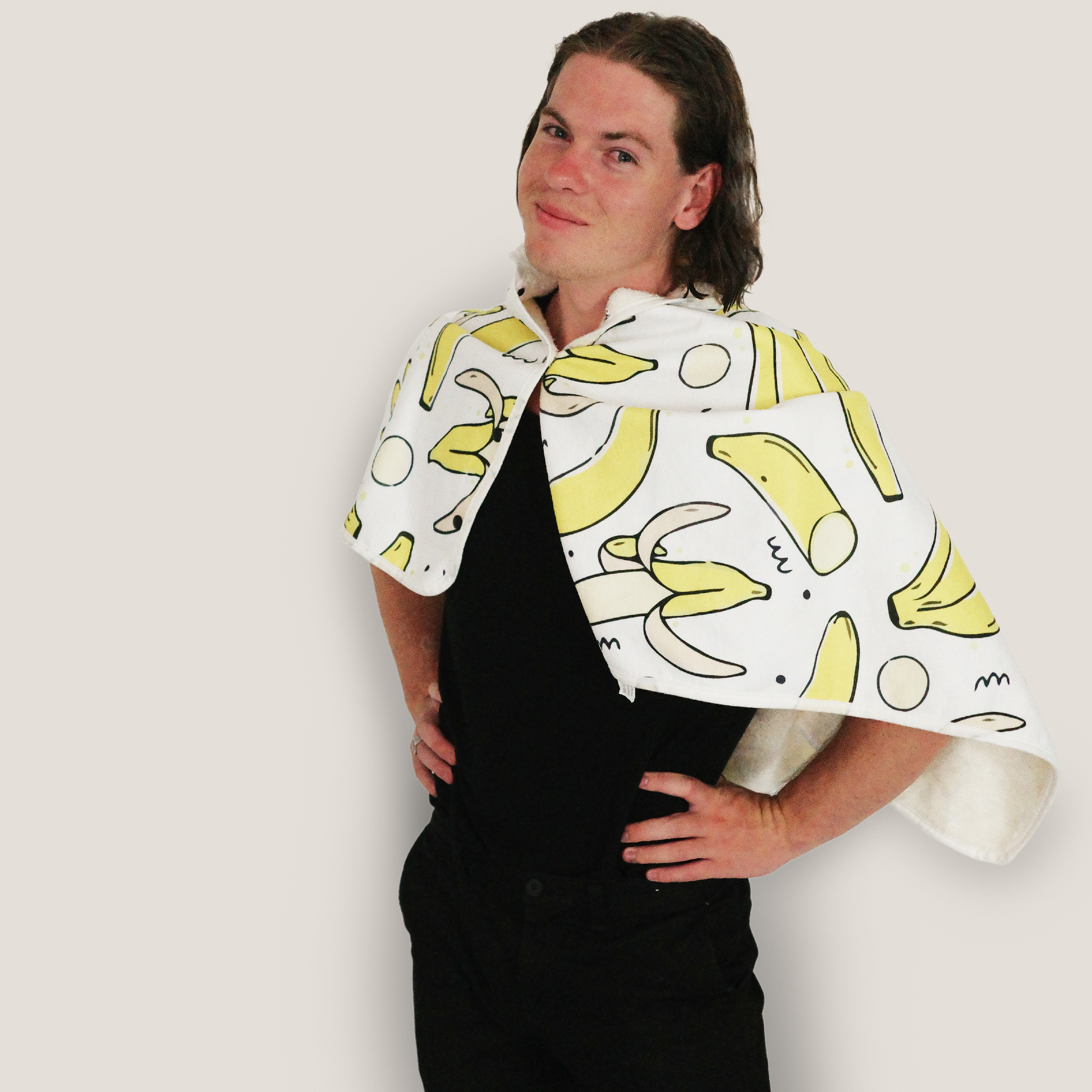 Man wearing a banana print cape blanket made from ultra-soft fleece. Stylish and comfortable wearable throw designed for warmth, relaxation, and fun everyday use.