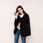 Model wearing a black fleece cape blanket with button closure, designed for ultimate warmth and style. A versatile and elegant wearable throw, reminiscent of a Batman cape.
